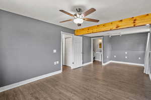 Spare room featuring ceiling fan, baseboards, and wood finished floors