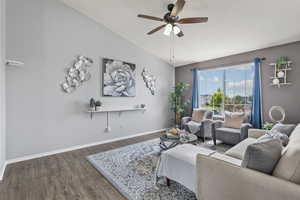 Living room with vaulted ceiling, wood finished floors, baseboards, and ceiling fan