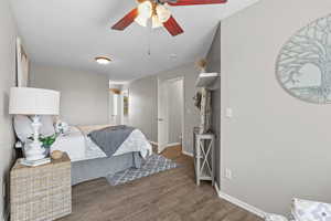 Bedroom with wood finished floors, baseboards, and ceiling fan