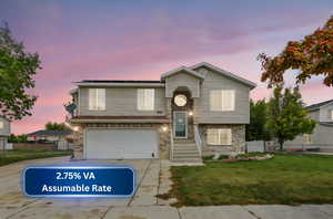 View of front facade featuring a yard, a garage, fence, and concrete driveway