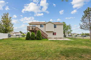 Rear view of property with a yard, a fenced backyard, and stairs
