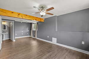 Unfurnished room featuring a sink, beam ceiling, wood finished floors, a ceiling fan, and baseboards