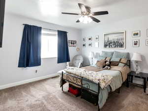 Carpeted bedroom with baseboards and ceiling fan