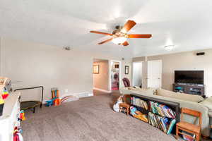 Recreation room featuring carpet, baseboards, ceiling fan, visible vents, and washer / dryer