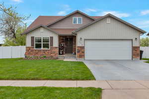Craftsman inspired home featuring a shingled roof, fence, an attached garage, and stone siding