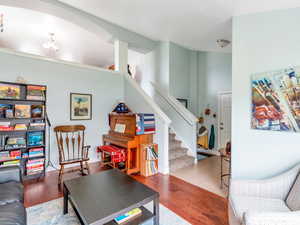 Living room featuring stairway, decorative columns, and wood finished floors