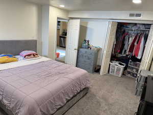 Bedroom with carpet floors, a closet, visible vents, and recessed lighting