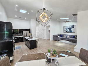 Living area with baseboards, light wood finished floors, and visible vents