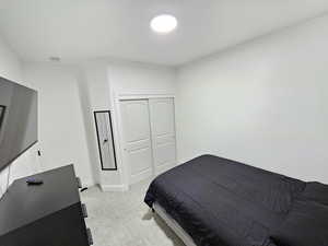 Bedroom with baseboards, light colored carpet, and a closet