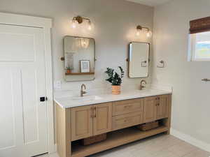 Full bathroom with a sink, baseboards, tile patterned floors, and double vanity