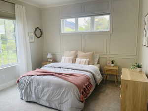 Bedroom with carpet floors, multiple windows, and a decorative wall