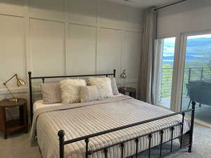 Bedroom featuring carpet flooring and a decorative wall