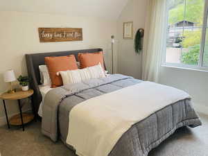 Bedroom featuring carpet flooring, baseboards, and lofted ceiling