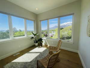 Sunroom / solarium featuring baseboards, a mountain view, a wealth of natural light, and hardwood / wood-style flooring