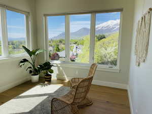 Sunroom with baseboards, a mountain view, and wood finished floors