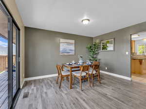 Dining room with baseboards, light wood-style floors, natural light