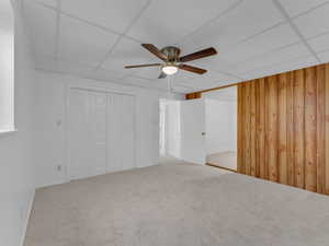 Unfurnished bedroom featuring carpet, and a ceiling fan, looking into a study