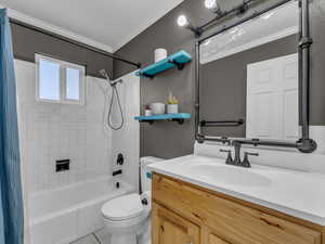 Full bath featuring shower / tub combo, toilet, tile patterned floors, vanity, and crown molding