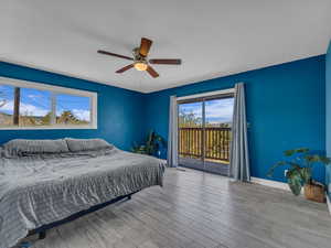 Main Bedroom featuring a ceiling fan, baseboards, access to outside, and deck. wood finished floors