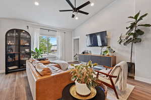 Living room featuring wood finished floors, high vaulted ceiling, recessed lighting, ceiling fan, and baseboards