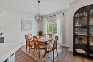 Dining space with a chandelier, wood finished floors, and baseboards