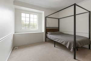 Bedroom featuring crown molding, carpet flooring, and visible vents