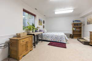 Bedroom featuring crown molding, light carpet, and visible vents