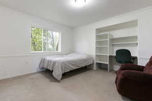 Bedroom with baseboards, ornamental molding, visible vents, and carpet
