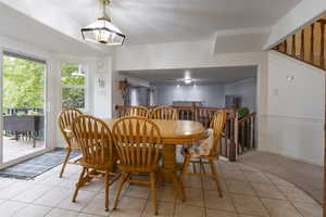 Dining area with a notable chandelier and light tile patterned flooring