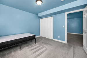 Carpeted bedroom featuring a closet and baseboards