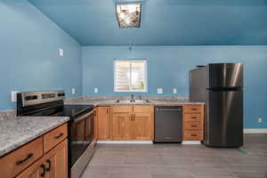 Kitchen featuring a sink, stainless steel appliances, and light countertops