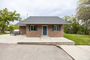 Single story home featuring roof with shingles, a front lawn, and brick siding