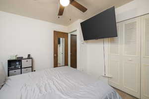 Bedroom with a closet, carpet, and a ceiling fan