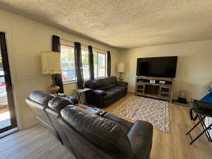 Living area with a textured ceiling and new floors