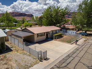 Single story home featuring a mountain view, metal roof, fence, and driveway