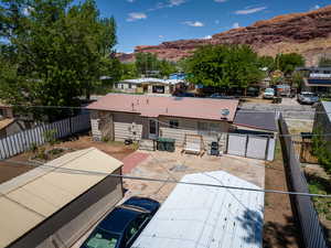 Back of property featuring a mountain view, metal roof, a fenced backyard, and a gate