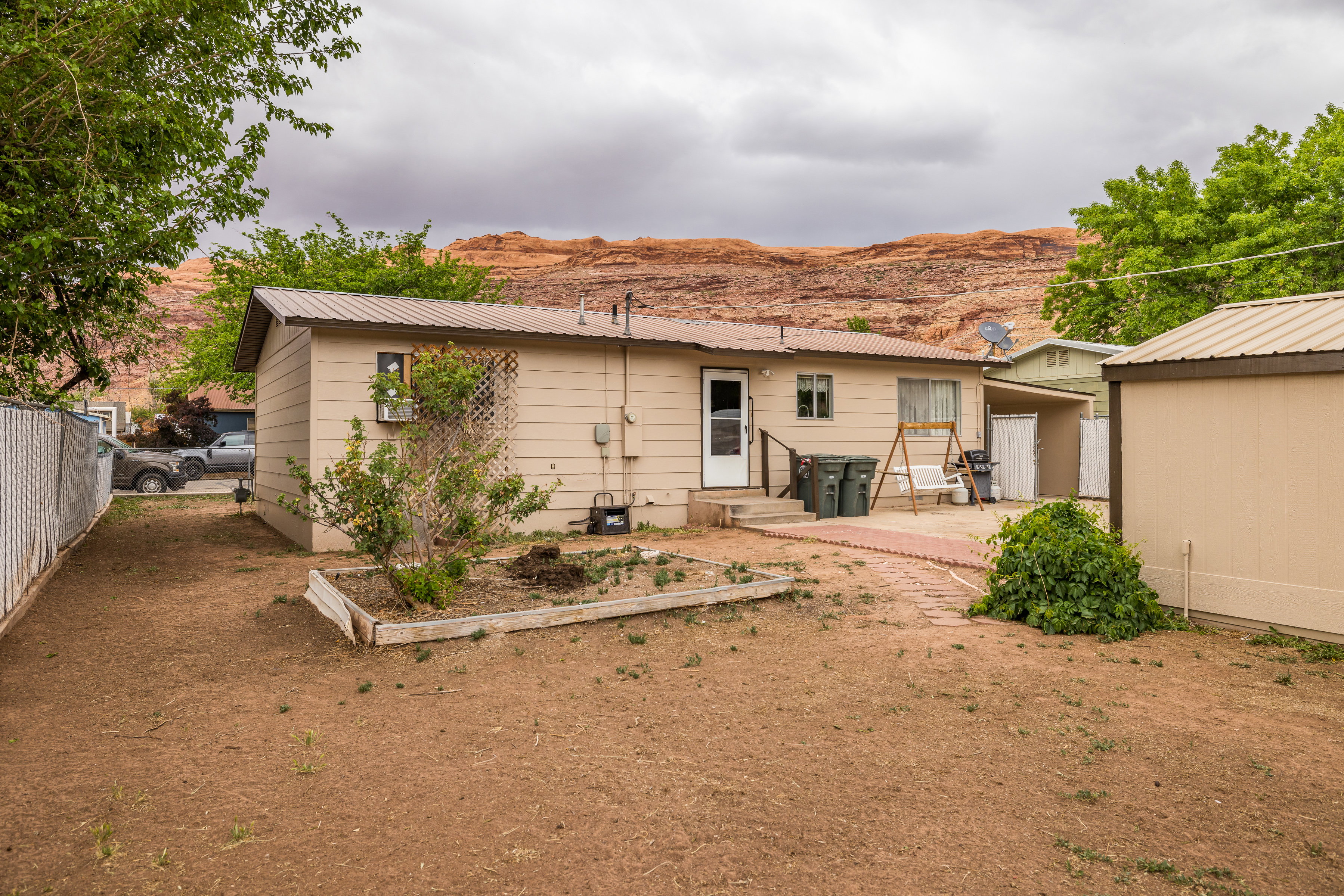 Rear view of house with fence, a patio area, metal roof, and a mountain view