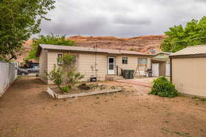 Rear view of house with fence, a patio area, metal roof, and a mountain view