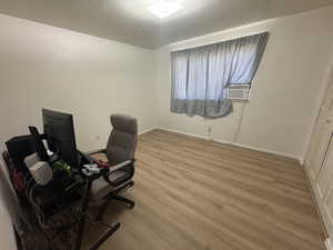 Office area featuring light wood-style flooring and cooling unit