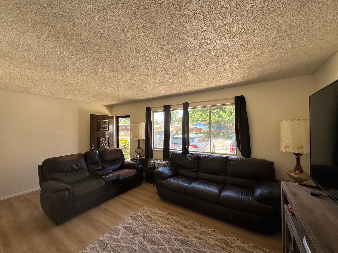 Living room with new floors and a textured ceiling