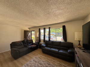 Living room with new floors and a textured ceiling