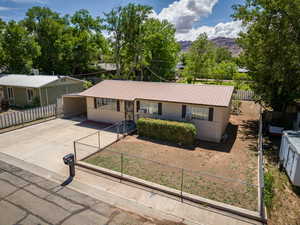 Ranch-style house featuring driveway, metal roof, and a mountain view