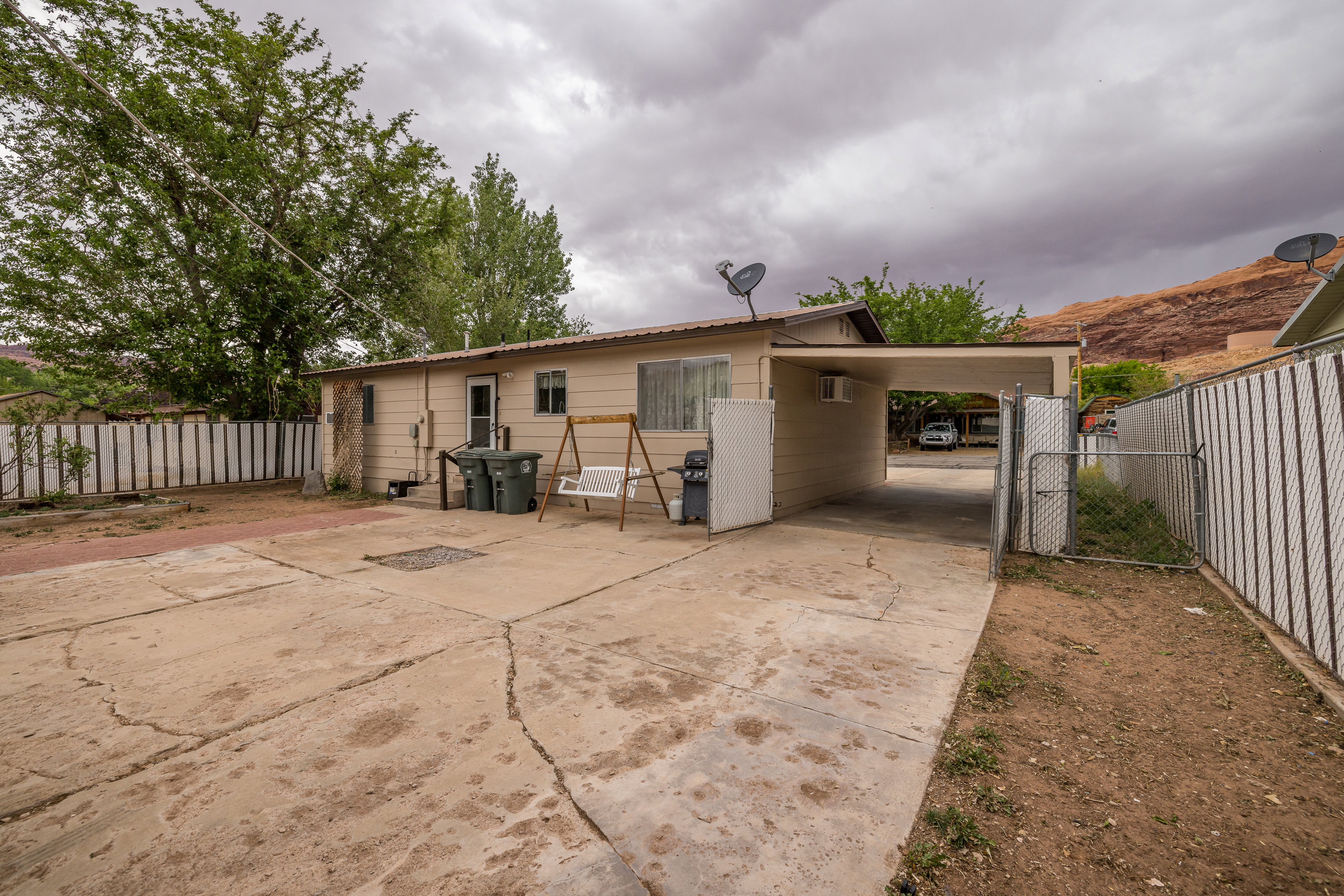 Back of property with fence and concrete driveway