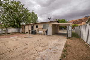 Back of property with fence and concrete driveway