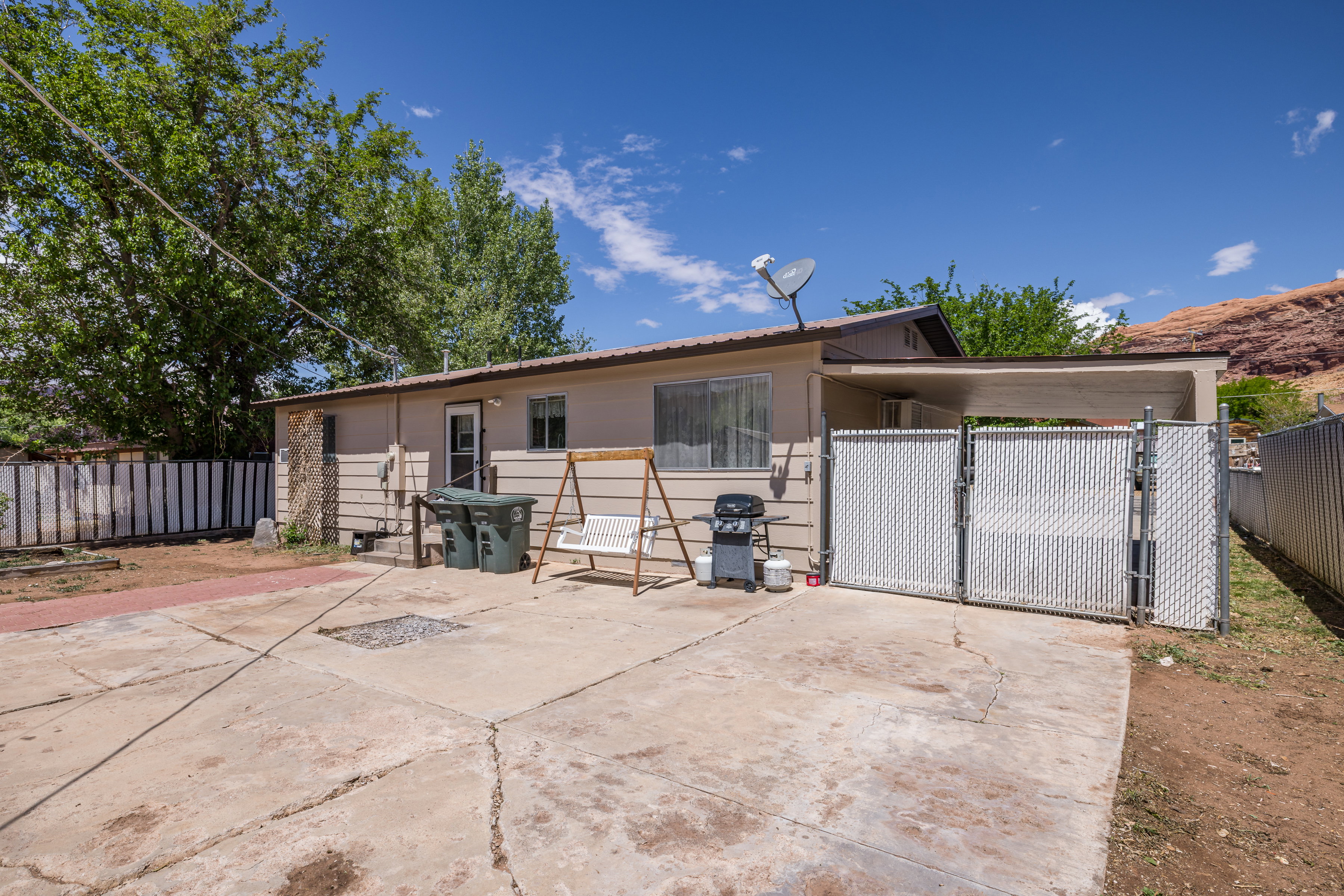 View of rear of home featuring a gate and fence