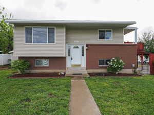 Split foyer home with brick siding and entry steps