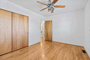 Unfurnished bedroom featuring a closet, visible vents, baseboards, and light wood-style flooring