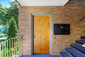 View of exterior entry featuring brick siding