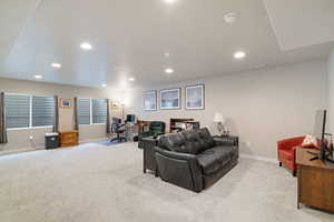 Living area with light carpet, baseboards, an office area, and recessed lighting