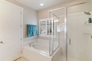 Full bathroom with a shower stall, a bath, and recessed lighting